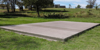 Shed being installed on a level concrete pad for maximum stability and durability