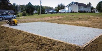 Prefab shed set on compacted gravel foundation for proper drainage and long-term support